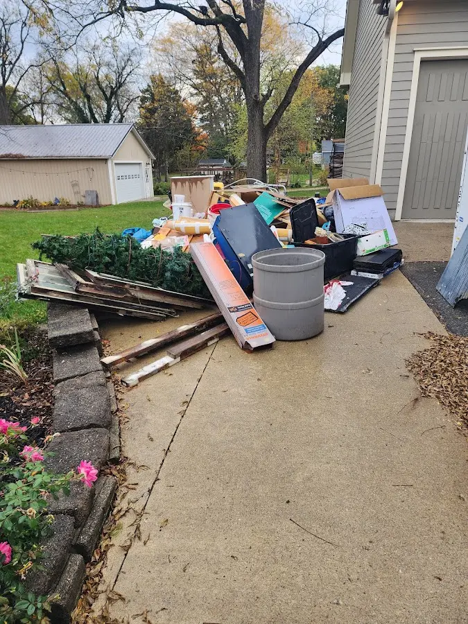 Dumpster being loaded with debris for Estate Cleanout Dumpster Rental in Green